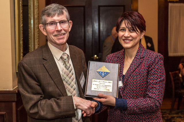 Jim O'Brien receiving past chair plaque from Pegah Jalili
