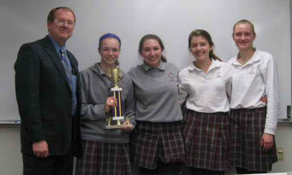 The Villa Duchesne teams (Rachel Arnold and Mary Hogan with trophy, Meghan Grojean and Nicole Saville providing team spirit) celebrate their winning titrations. Battle Coordinator Bruce Ritts presented the trophy.