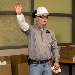 EHS Manager Justin Kuehnel shows off his arm coverings, a new safety requirement.